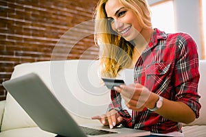 Pretty blonde using laptop on couch