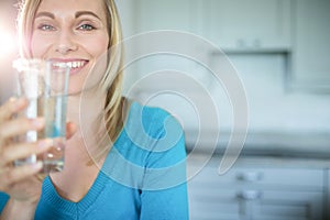 Pretty blonde woman drinking a glass of water