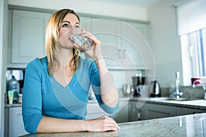 Pretty blonde woman drinking a glass of water