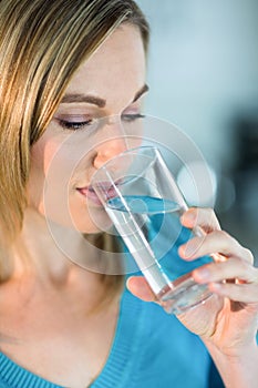 Pretty blonde woman drinking a glass of water