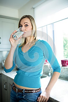 Pretty blonde woman drinking a glass of water