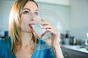 Pekný blondínka žena pitie pohár voda 