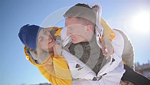 Pretty Blonde Woman is Hugging Handsome Man Sitting on His Shoulders During Winter Vacation in the Mountains. Closeup