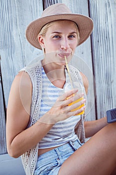 Pretty blonde woman using her tablet and drinking orange juice