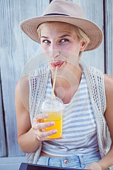 Pretty blonde woman using her tablet and drinking orange juice