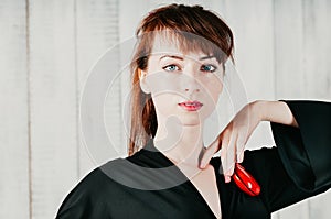 Pretty blue-eyed woman in black dress, with red castanets, light