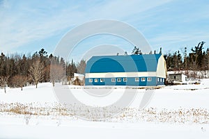 Pretty blue and white barn in a rural part of town seen in winter