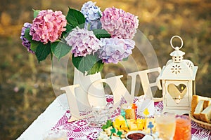 Pretty bouquet of hydrangea flowers in a vintage jar. Flower decor on the garden table.