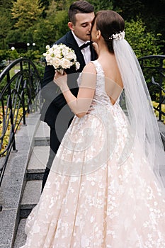 Pretty bride kid her groom, husband during wedding ceremony. Woman hold bouquet and hug groom