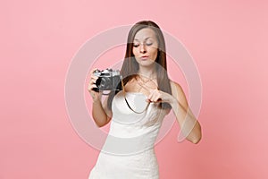 Pretty bride woman in white wedding dress pointing index finger on retro vintage photo camera choosing staff