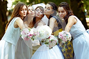 Pretty bridesmaids surround a bride holding wedding bouquets in