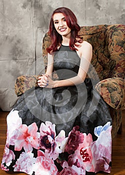 Pretty brown-eyed redhead girl reclining in chair