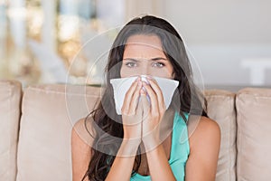 Pretty brunette blowing her nose