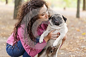 Pretty brunette girl walking with dog in the park. Animal concept.