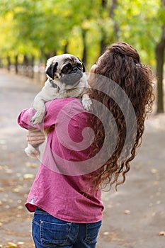 Pretty brunette girl walking with dog in the park. Animal concept.