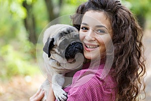 Pretty brunette girl walking with dog in the park. Animal concept.