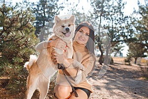 Pretty brunette girl walking with dog in the park. Animal concept.