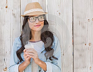 Pretty brunette holding take away coffee