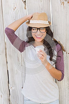 Pretty brunette holding take away coffee