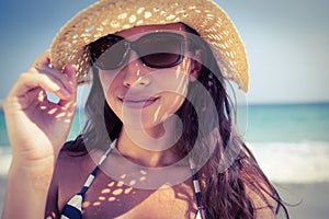 Pretty brunette looking at camera at the beach