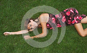 Pretty brunette lying on the grass