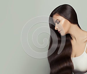 Pretty brunette model woman with long healthy brown hair on white background. Haircare and facial treatment concept