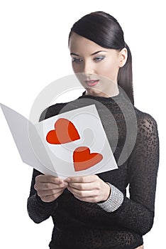 Pretty brunette reads valentine postcard