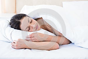 Pretty brunette sleeping on bed photo