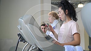 Pretty brunette uses phone walking at the treadmill