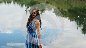 Pretty brunette woman in a beautiful dress enjoys nature