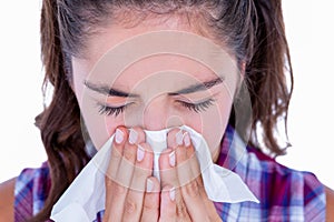 Pretty brunette woman blowing her nose