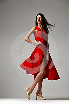 Pretty brunette woman in formal red dress stiletto heels shoes