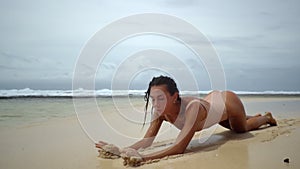 Pretty brunette woman posing on sandy beach