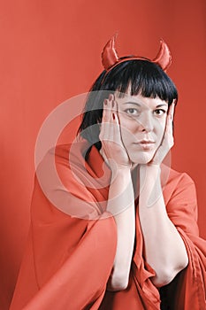 Pretty brunette woman with the red devil horns