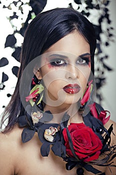 pretty brunette woman with rose jewelry, black and red, bright make up like a vampire closeup red lips