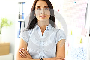 Pretty brunette woman standing with hands crossed