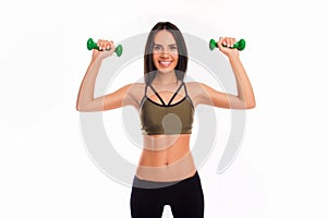 Pretty brunette working out with dumbbells on white background
