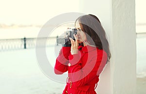 Pretty brunette young woman with retro vintage camera in winter