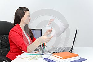 Pretty Business woman analyzing investment charts with calculator and laptop