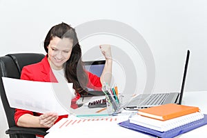 Pretty Business woman analyzing investment charts with calculator and laptop