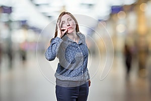 Pretty business woman making silence gesture over blur background