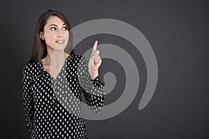 Pretty business woman over black board pointing with fi