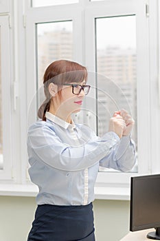 pretty business woman in strict stylish clothes and glasses in the office near the desktop crumples documents