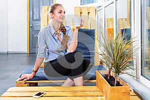 Pretty businesswoman drinking hot morning coffee and dreaming in modern loft. Woman in businness. Freelancer in