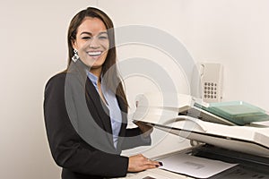 Pretty businesswoman making copies