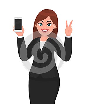 Pretty businesswoman showing blank screen mobile, cell or smart phone and gesturing or making victory, V or peace sign with hand.