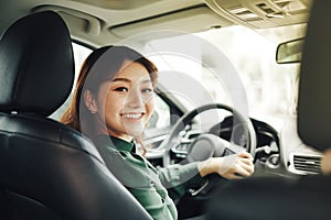 Pretty businesswoman smiling and driving in her car