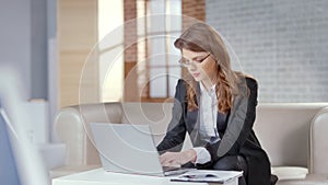 Pretty businesswoman working on laptop in expensive office, responsible officer