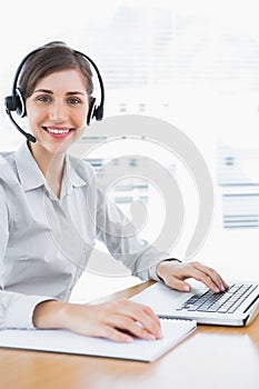 Pretty call centre agent working at desk