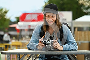 Pretty caucasian female traveller with backpack sitting at outdoor street food restaurant